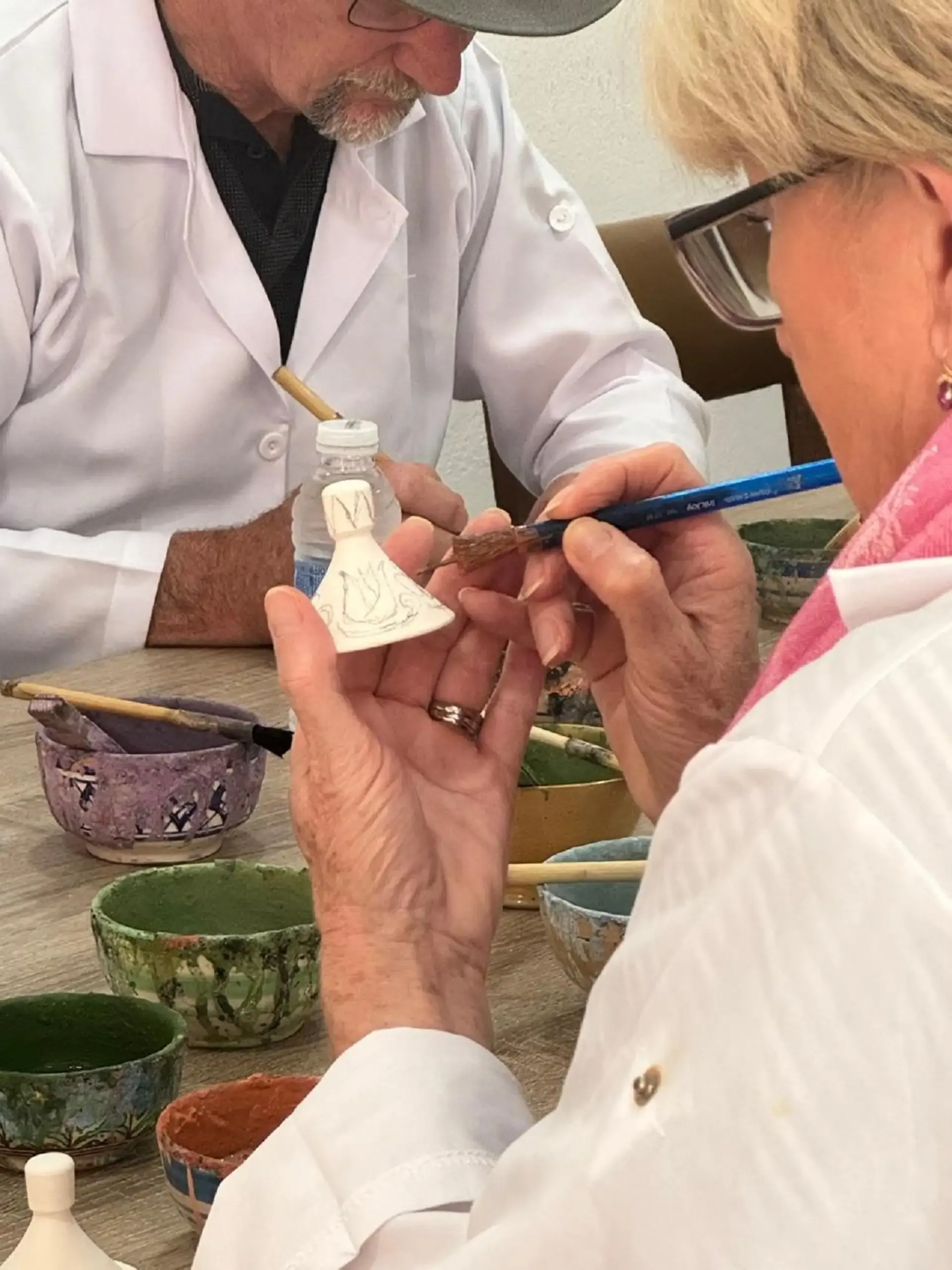 Peinture à la main sur une pièce de céramique pendant un atelier à Fès